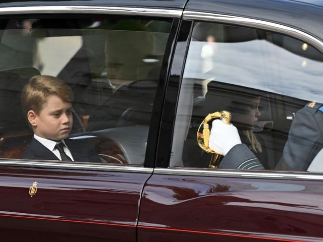 Prince George of Wales and Princess Charlotte of Wales are driven in car along the Mall after the State Funeral of Queen Elizabeth II.