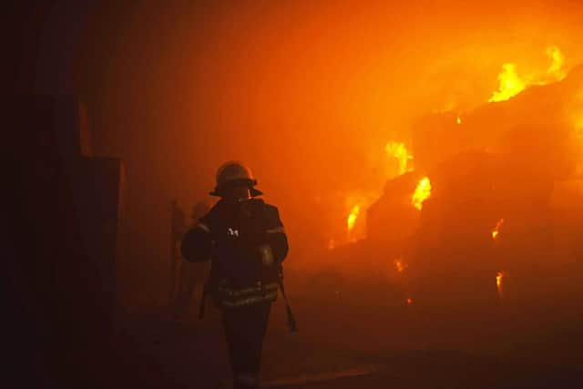 A rescuer putting out a fire in a building as a result of falling debris after a massive drone attack mainly targeting the Ukrainian capital Kyiv. Picture: Pavlo Petrov/State Emergency Service of Ukrai/AFP via Getty Images