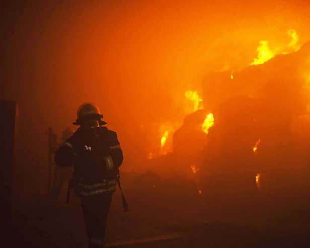 A rescuer putting out a fire in a building as a result of falling debris after a massive drone attack mainly targeting the Ukrainian capital Kyiv. Picture: Pavlo Petrov/State Emergency Service of Ukrai/AFP via Getty Images
