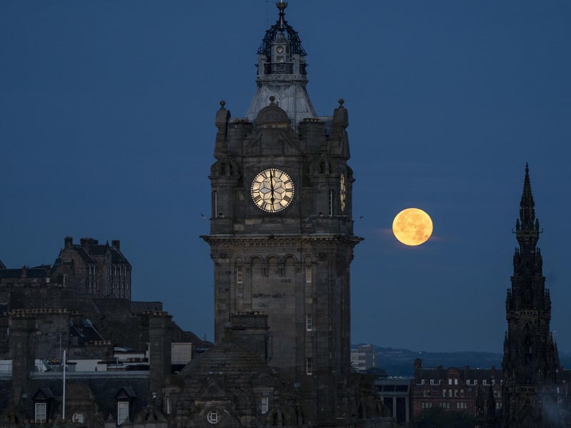 The super blue moon sets between the Balmoral Clock and the Scott Monument in Edinburgh.Photo: Jane Barlow/PA Wire