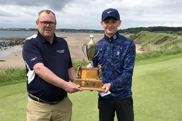 Lucas Lloyd, a member of the winning Lundin team in the Fife Junior Team Championship, is presented with the trophy by FGA junior convenor David Landsburgh. Picture: FGA