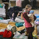 A girl holds her sibling in a temporary shelter for Ukrainian refugees at a school in Przemysl, near the Ukrainian-Polish border (Picture: Louisa Gouliamaki/AFP via Getty Images)