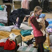 A girl holds her sibling in a temporary shelter for Ukrainian refugees at a school in Przemysl, near the Ukrainian-Polish border (Picture: Louisa Gouliamaki/AFP via Getty Images)