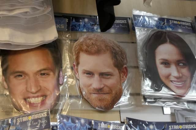 Masks showing Britain's Prince William, Prince Harrry, and his wife Meghan, right, are seen for sale in a shop in London, Friday, Jan. 6,