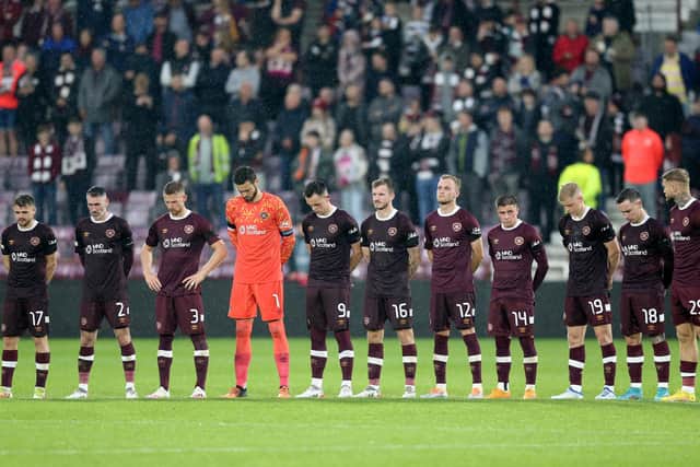 Hearts players stand wearing black armbands before the second half following the announcement of the death of Queen Elizabeth II, during the UEFA Europa Conference League Group A match at Tynecastle Park, Edinburgh.