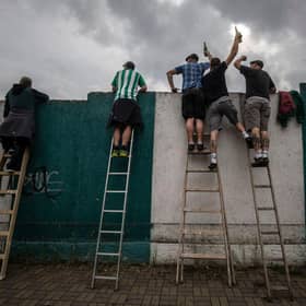 Football fans have been using ladders to get a glimpse of their team. Picture: Gabriel Kuchta/Getty Images