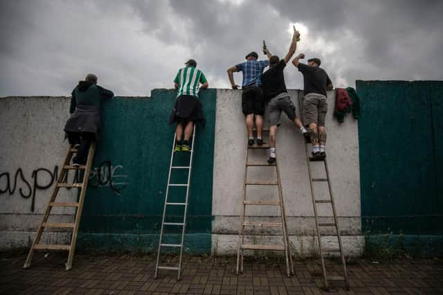 Football fans have been using ladders to get a glimpse of their team. Picture: Gabriel Kuchta/Getty Images