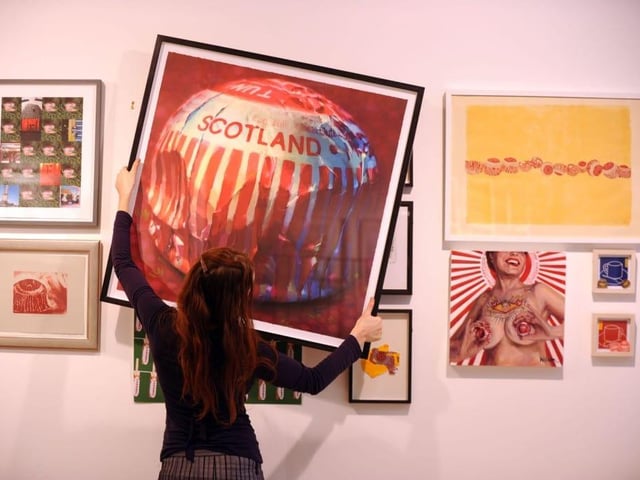 There was a Tunnock’s exhibition at the Glasgow Print Studio in 2010 titled Tunnocked. Here print studio assistant Olivia Bliss moves the artworks around.