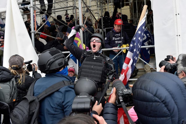 A man calls on people to raid the building as Trump supporters clash with police and security forces as they try to storm the US Capitol in Washington D.C on January 6, 2021. - Demonstrators breeched security and entered the Capitol as Congress debated the a 2020 presidential election Electoral Vote Certification. (Photo by Joseph Prezioso / AFP)