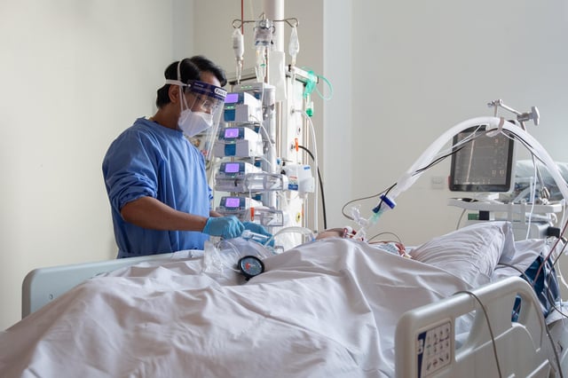 A nurse checking on a patient suffering with Covid-19 on the critical care unit.