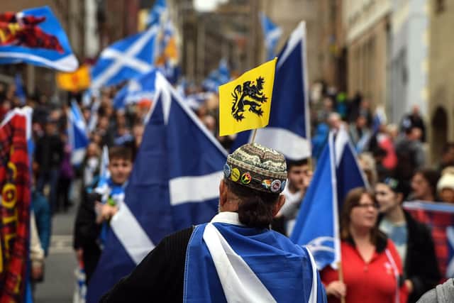 Pro-independence activists wave Scottish Saltire flags as they march from Holyrood to the Meadows in Edinburgh. (Picture: Andy Buchanan/AFP via Getty Images)