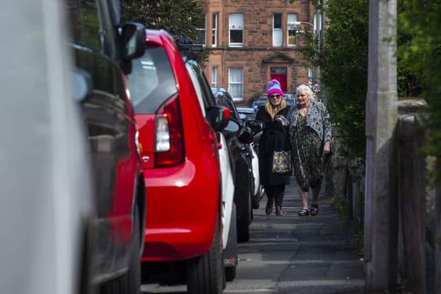 Pedestrians struggling to get past cars parked on an Edinburgh pavement. Picture: Lisa Ferguson