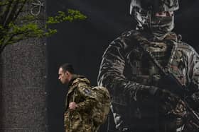 A Ukrainian serviceman walks past a recruiting poster in Kyiv amid the Russian invasion of Ukraine. Picture: Sergei Supinsky/AFP via Getty Images