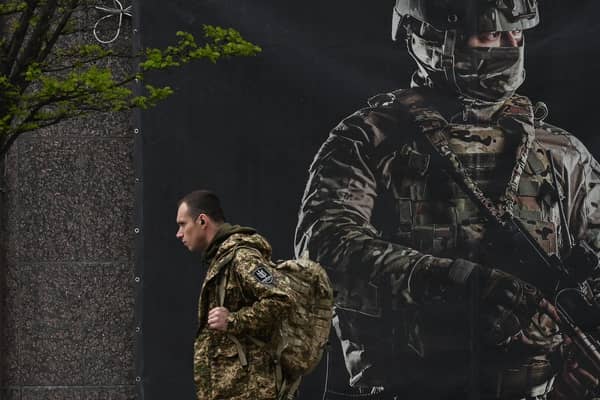 A Ukrainian serviceman walks past a recruiting poster in Kyiv amid the Russian invasion of Ukraine. Picture: Sergei Supinsky/AFP via Getty Images