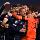 David Marshall (in orange) is mobbed by his Scotland team-mates after his penalty save in the shoot-out against Serbia ensured Scotland's qualification for Euro 2020, which will be played this summer. Picture: Srdjan Stevanovic/Getty Images