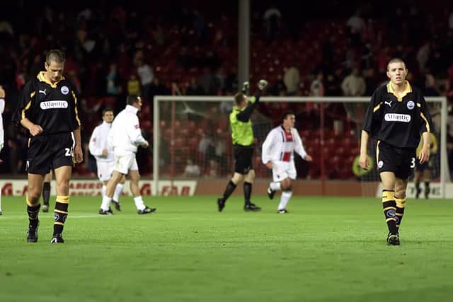 Dejected Aberdeen players troop off at the final whistle as their Irish guests Bohemians celebrate a sensational UEFA Cup victory at Pittodrie in 2000.