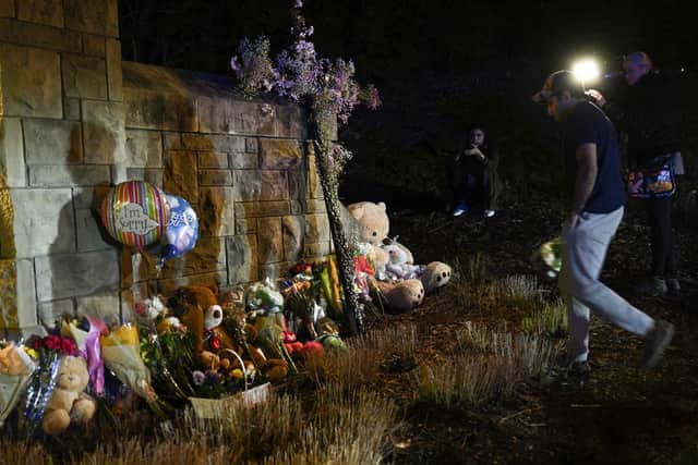 A man drops flowers to a makeshift memorial where baloons and Teddy bears are left on the outside the Covenant School building at the Covenant Presbyterian Church, in Nashville, Tennessee, March 27. -(Photo by BRENDAN SMIALOWSKI/AFP via Getty Images)