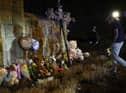 A man drops flowers to a makeshift memorial where baloons and Teddy bears are left on the outside the Covenant School building at the Covenant Presbyterian Church, in Nashville, Tennessee, March 27. -(Photo by BRENDAN SMIALOWSKI/AFP via Getty Images)