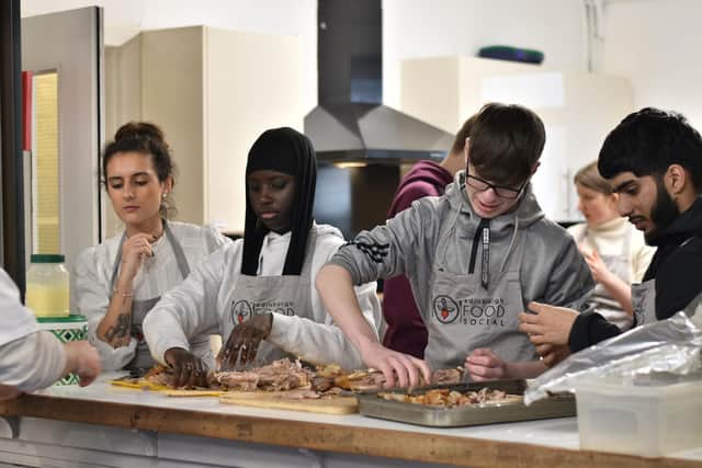 Young people working in the kitchen.