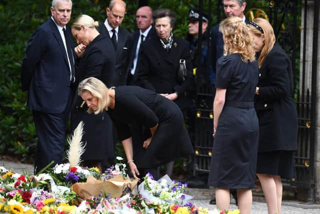 Members of the Royal Family view flowers left at Balmoral Castle. (Pic: Michael Gillen)