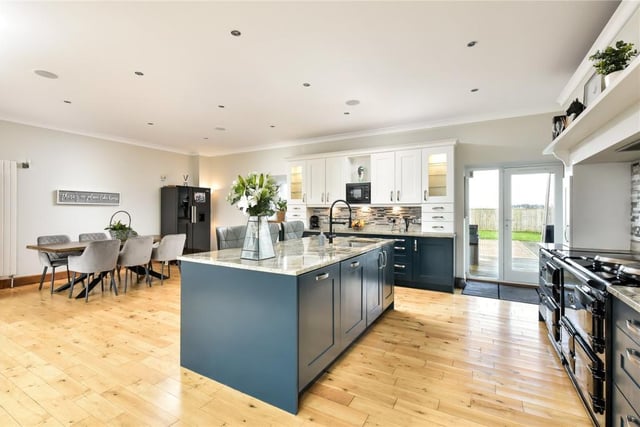 The kitchen fittings include granite surfaces and a central island with breakfast bar and sink with hot water tap, while the electric AGA has four doors.