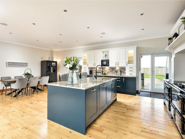 The kitchen fittings include granite surfaces and a central island with breakfast bar and sink with hot water tap, while the electric AGA has four doors.