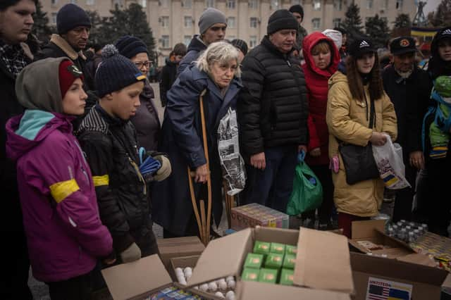 People in newly liberated Kherson crowd around volunteers to receive humanitarian food (Picture: Chris McGrath/Getty Images)