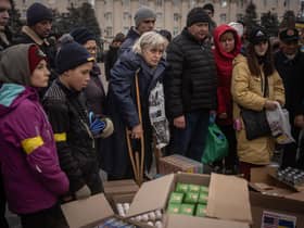 People in newly liberated Kherson crowd around volunteers to receive humanitarian food (Picture: Chris McGrath/Getty Images)