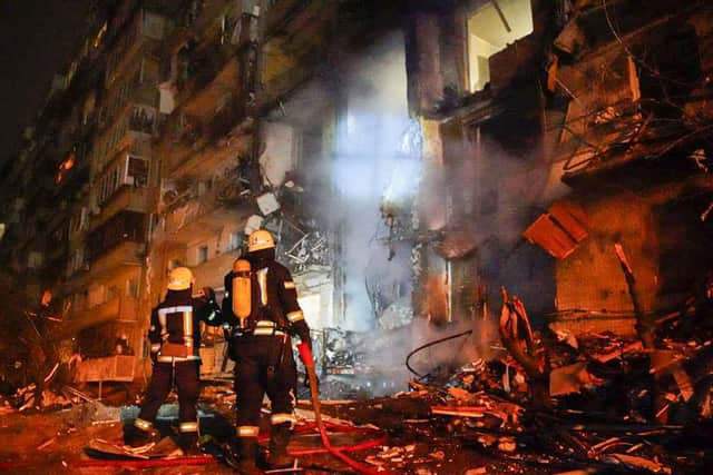 Firefighters inspect the damage at a building following a rocket attack in Kyiv