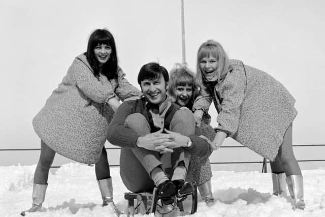 The star enjoying a holiday in the mountains of Switzerland where his sleigh gets a gentle push from The Dollies, a pop group from Manchester (Picture: PA Wire)