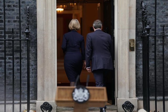 Liz Truss, with her husband Hugh O'Leary, walks back into 10 Downing Street, London, after making a statement where she announced her resignation as Prime Minister.