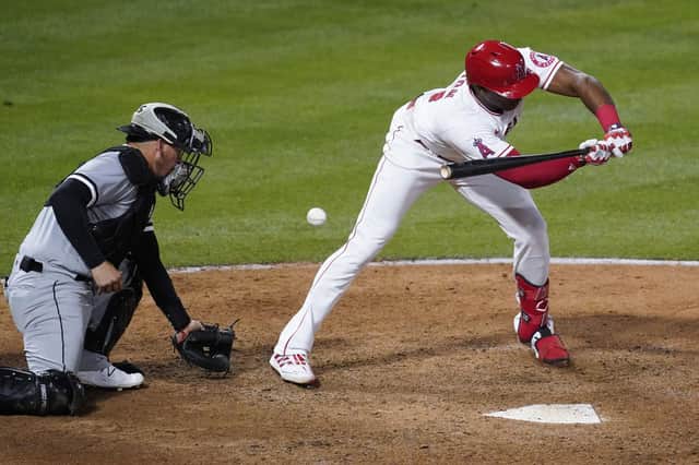 Los Angeles Angels' Justin Upton, right, is hit by a pitch from Chicago White Sox relief pitcher Aaron Bummer.