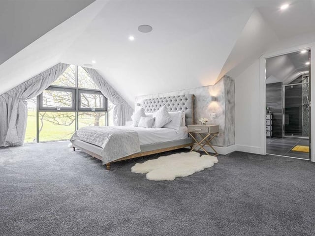 Master bedroom with stunning outlook through gable-shaped window wall.