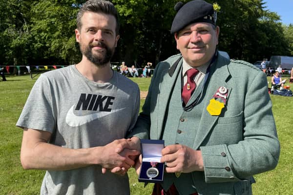 Antony Daffurn (left) accepts historic medal from Scott Fraser (right)-