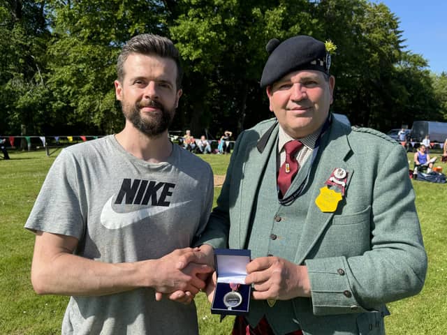 Antony Daffurn (left) accepts historic medal from Scott Fraser (right)-