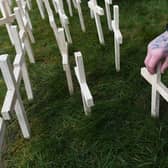 A man leaves a cross for his brother during an event to remember the victims of drugs at Springburn Parish Church in Glasgow last year