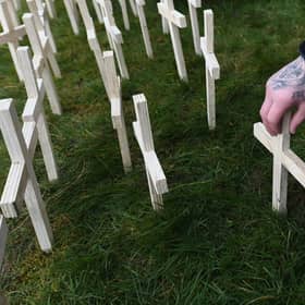 A man leaves a cross for his brother during an event to remember the victims of drugs at Springburn Parish Church in Glasgow last year