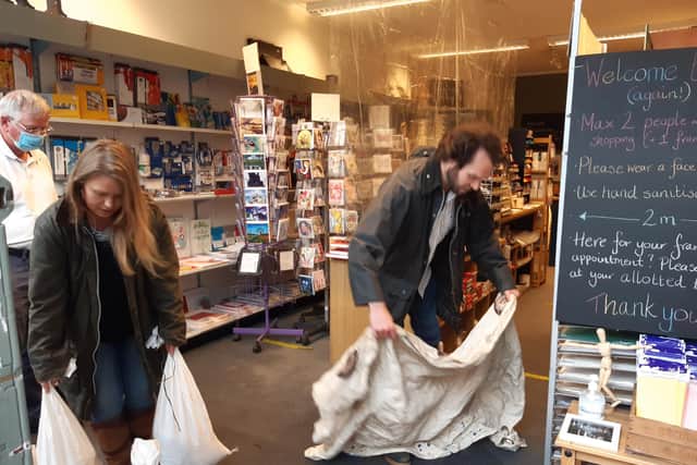 Tom and Lauren Holmes, owners of Henderson Art Shop on Raeburn Place, clean up after the flood