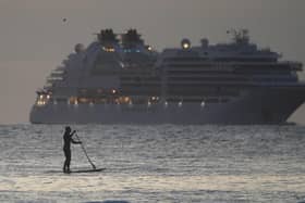 A paddleboarder in the foreground as the Seabourn Ovation cruise ship arrives. Picture: Owen Humphreys/PA Wire