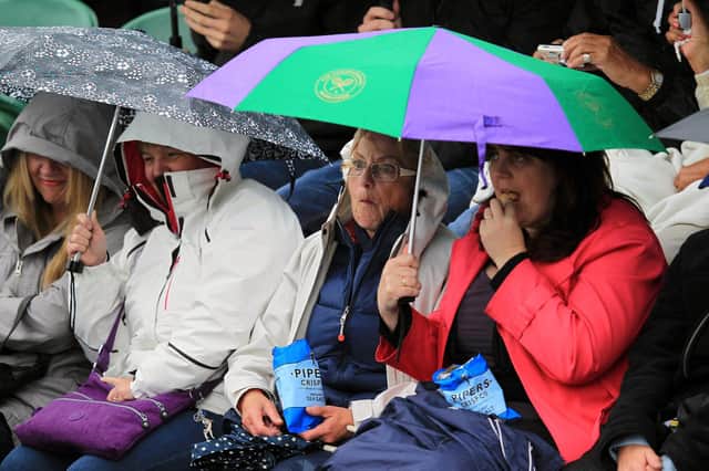 Tennis fans console themselves with crisps on a rainy day at Wimbledon (Picture: Mike Egerton/PA)