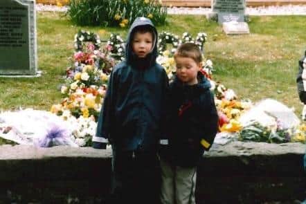 Andrew and his brother at their father's graveside.