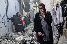 People find their way through a rubble-covered alley, following overnight Israeli bombardment in Rafah in the southern Gaza Strip, amid continuing battles between Israel and Palestinian militant group Hamas. Photo: SAID KHATIB/AFP via Getty Images