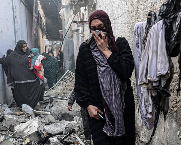 People find their way through a rubble-covered alley, following overnight Israeli bombardment in Rafah in the southern Gaza Strip, amid continuing battles between Israel and Palestinian militant group Hamas. Photo: SAID KHATIB/AFP via Getty Images