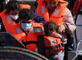 A group of people, including a child, thought to be migrants are brought in to Dover, Kent, following a small boat incident in the Channel earlier this month.  Photo: Gareth Fuller/PA Wire