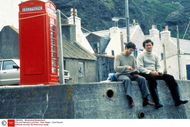 Actors  Peter Riegert (Mac) and Chris Rozycki (Viktor) in Bill Forsyth classic Local Hero, which was partly shot in Pennan, Aberdeenshire. The phonebox was originally constructed as part of a set with a permanent working phone then installed nearby. Photo by Moviestore/Shutterstock