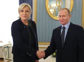 Marine Le Pen shakes hands with Vladimir Putin in 2017, three years after his forces annexed Crimea from Ukraine (Picture: Mikhail Klimentyev/AFP via Getty Images)