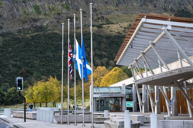 The flags outside the Scottish Parliament at Holyrood, Edinburgh, fly at half mast this weekend following the death of Alex Salmond. Photo: Jane Barlow/PA Wire