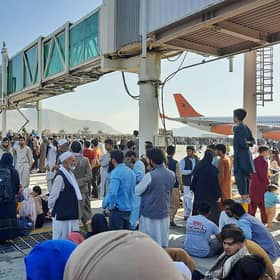 Afghans crowd the tarmac of Kabul airport on 16 August, 2021, trying to flee the country after the Taliban took control PIC: AFP via Getty Images