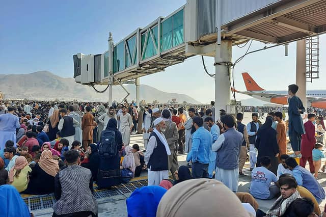 Afghans crowd the tarmac of Kabul airport on 16 August, 2021, trying to flee the country after the Taliban took control PIC: AFP via Getty Images