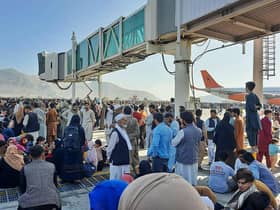Afghans crowd the tarmac of Kabul airport on 16 August, 2021, trying to flee the country after the Taliban took control PIC: AFP via Getty Images